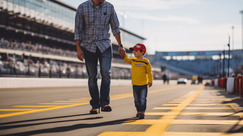 dad and his son walking down the track at an auto race