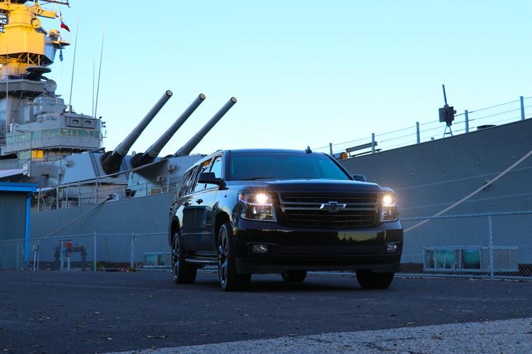 black chevrolet suburban in front of battleship uss iowa