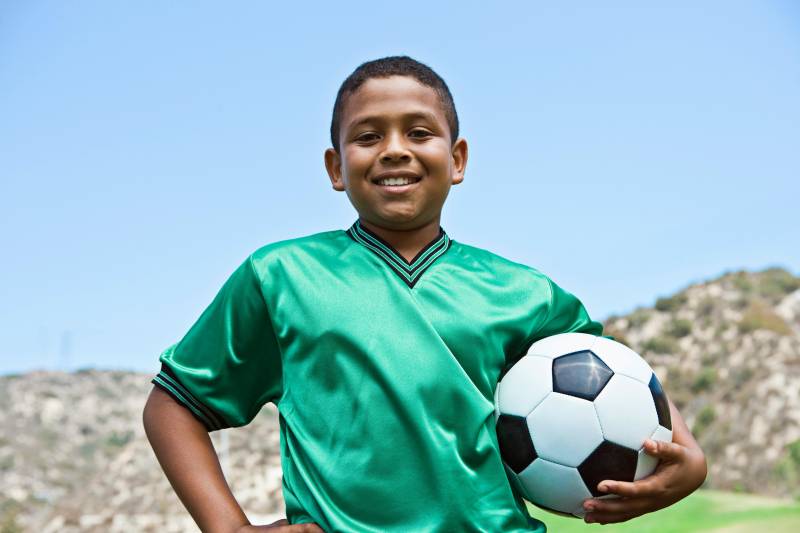 happy kid playing soccer