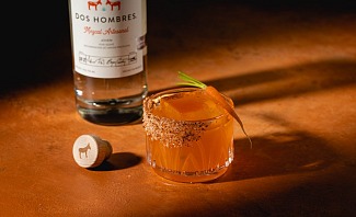 Dos Hombres Mezcal bottle with Sweet Lips cocktail featuring chili salt rim and carrot garnish